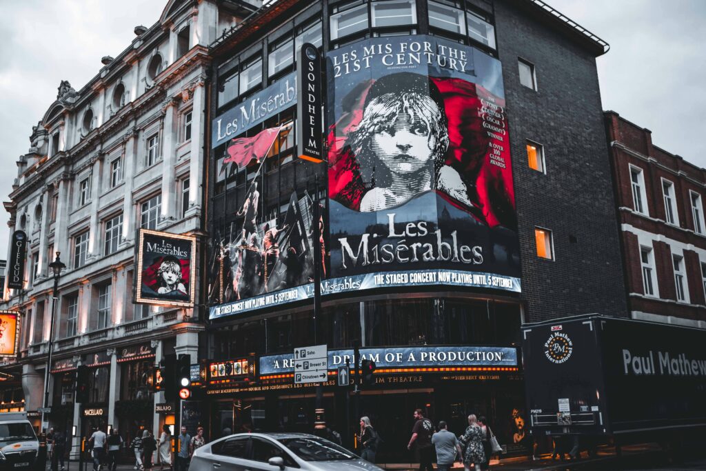 Facade of Sondheim Theatre in London displaying Les Misérables posters.